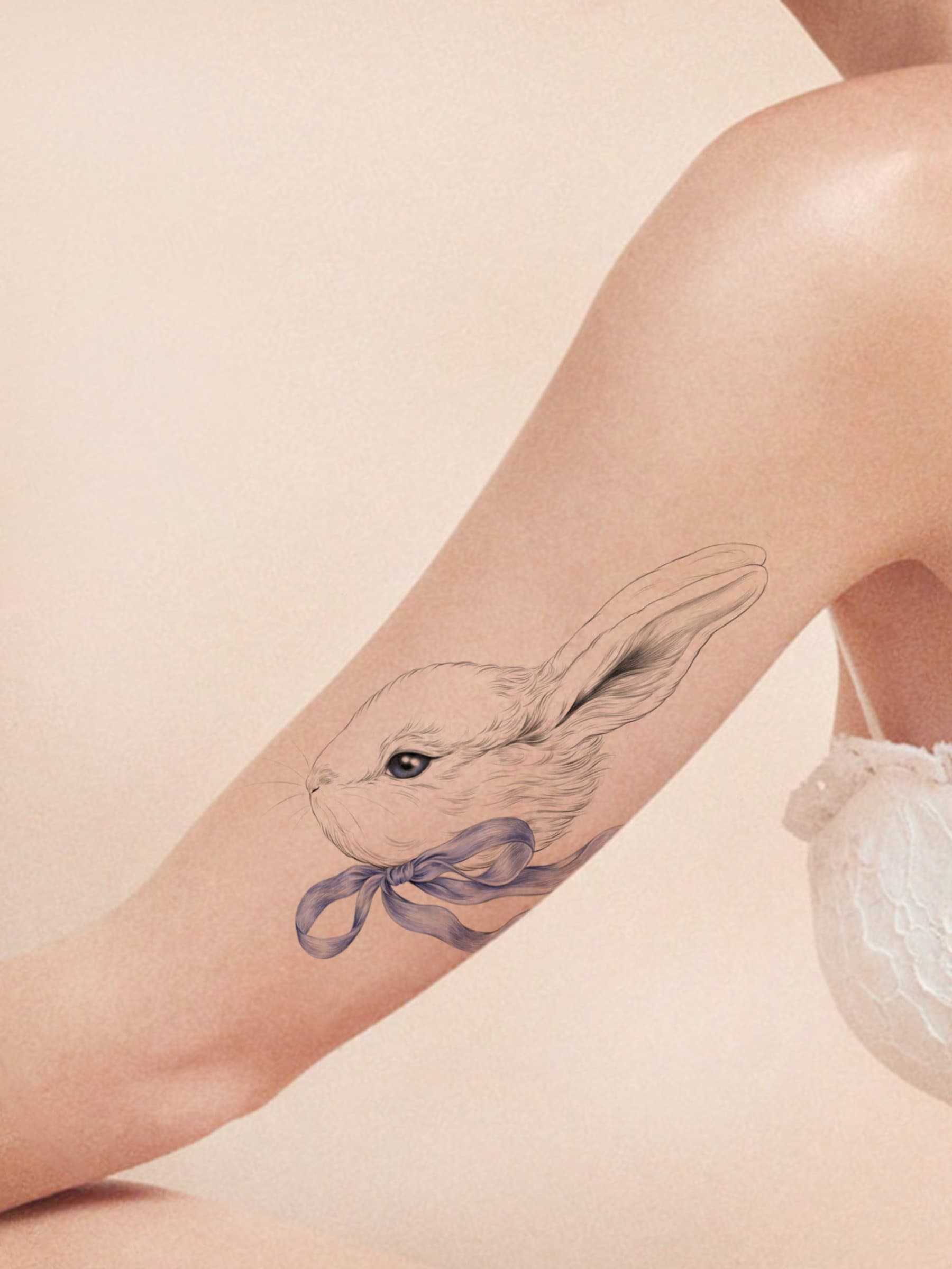 Micro-realistic rabbit tattoo located on the upper arm.